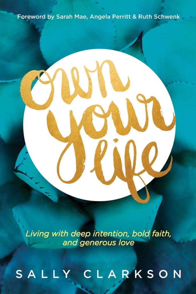 Book cover for "Own Your Life" by Sally Clarkson. The background shows flower petals overlayed with a blue hue.