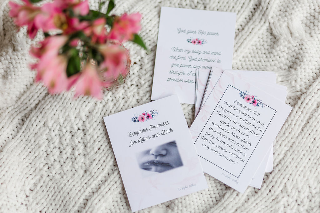 labor and delivery cards. It depicts the cards spread out on the white table cloth with the pink flowers beside them.