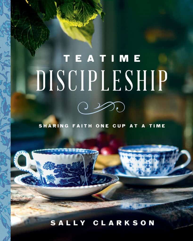 Cover of "Teatime Discipleship" by Sally Clarkson. It shows two cups of blue china on saucers setting on a brown wooden table.