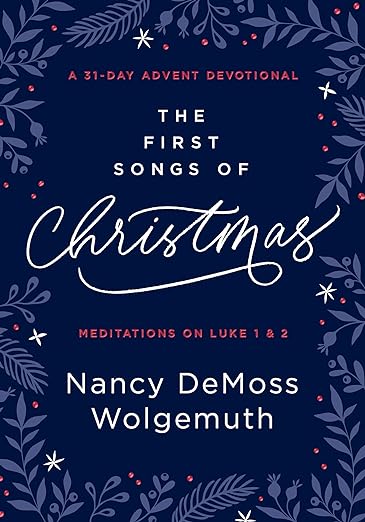 Book cover for "The First Songs of Christmas" by Nancy DeMoss Wolgemuth. It features the title on a deep blue background. Around the edges are white snowflakes and evergreen branches.