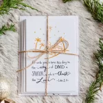 Beautiful Christmas Cards wrapped in a twine bow and laid on soft fir with pine branches around it.