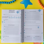 The Prayer Journal on yellow paper surrounded by beads. It is open to the main prayer request page.