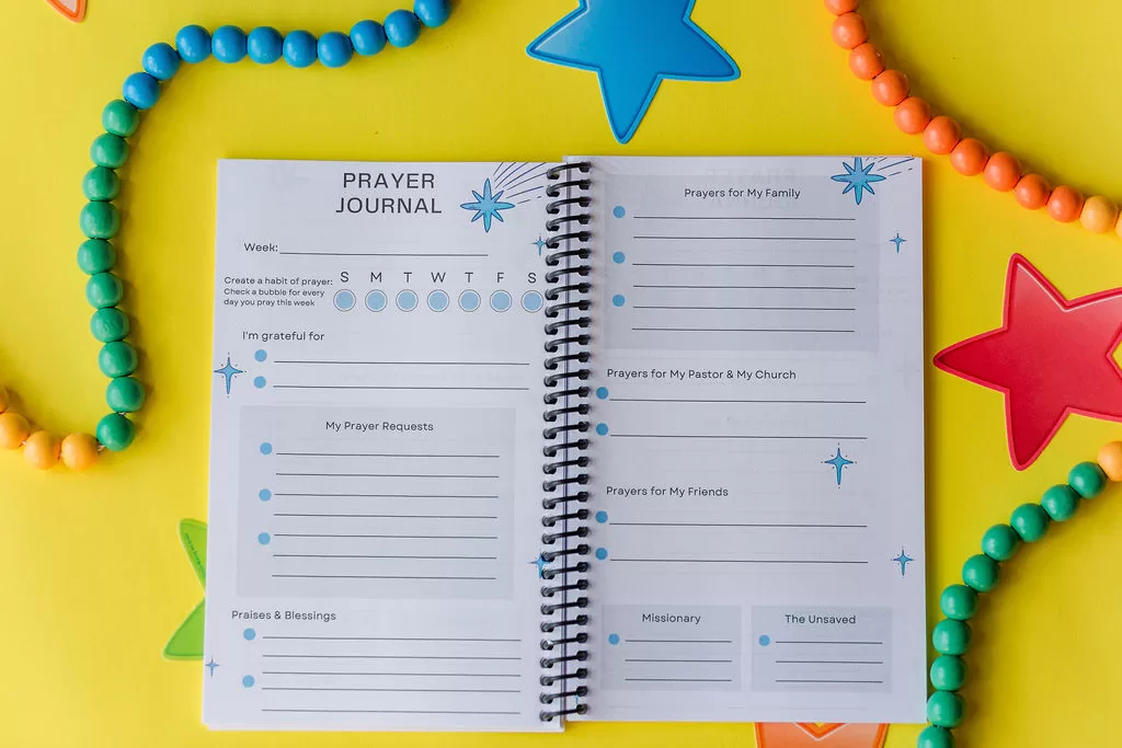 The Prayer Journal on yellow paper surrounded by beads. It is open to the main prayer request page.